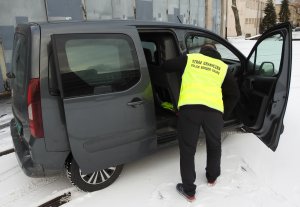Fot. MOSG Funkcjonariusz Straży Granicznej sprawdza kradziony samochód.