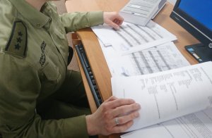 Fot. MOSG Funkcjonariuszka Straży Granicznej podczas kontroli dokumentów.