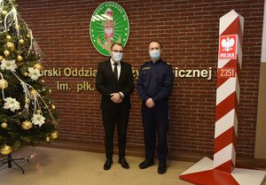 Fot. Ł. Zwoliński Komendant MOSG i p.o. Okręgowego Inspektora Pracy stoją przy ścianie z napisem Morski Oddział Straży Granicznej.