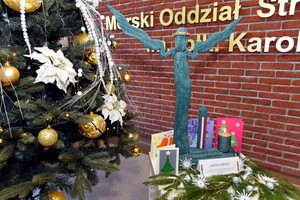 Fot. MOSG Rzeźba anioła i kartki świąteczne leżą pod choinką.