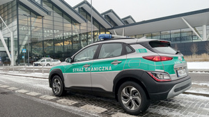 Fot. MOSG Samochód Straży Granicznej stoi przed terminalem lotniska.