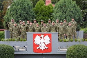 Fot. OSSSG Funkcjonariusze stoją za godłem Polski.