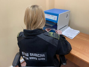 Funkcjonariuszka Straży Granicznej sprawdza dokument Funkcjonariuszka Straży Granicznej sprawdza dokument