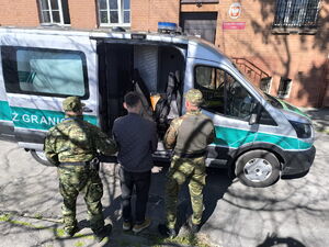 Funkcjonariusze doprowadzają do pojazdu służbowego zatrzymanego obywatela Ukrainy. Fot. MOSG Funkcjonariusze doprowadzają do pojazdu służbowego zatrzymanego obywatela Ukrainy. Fot. MOSG